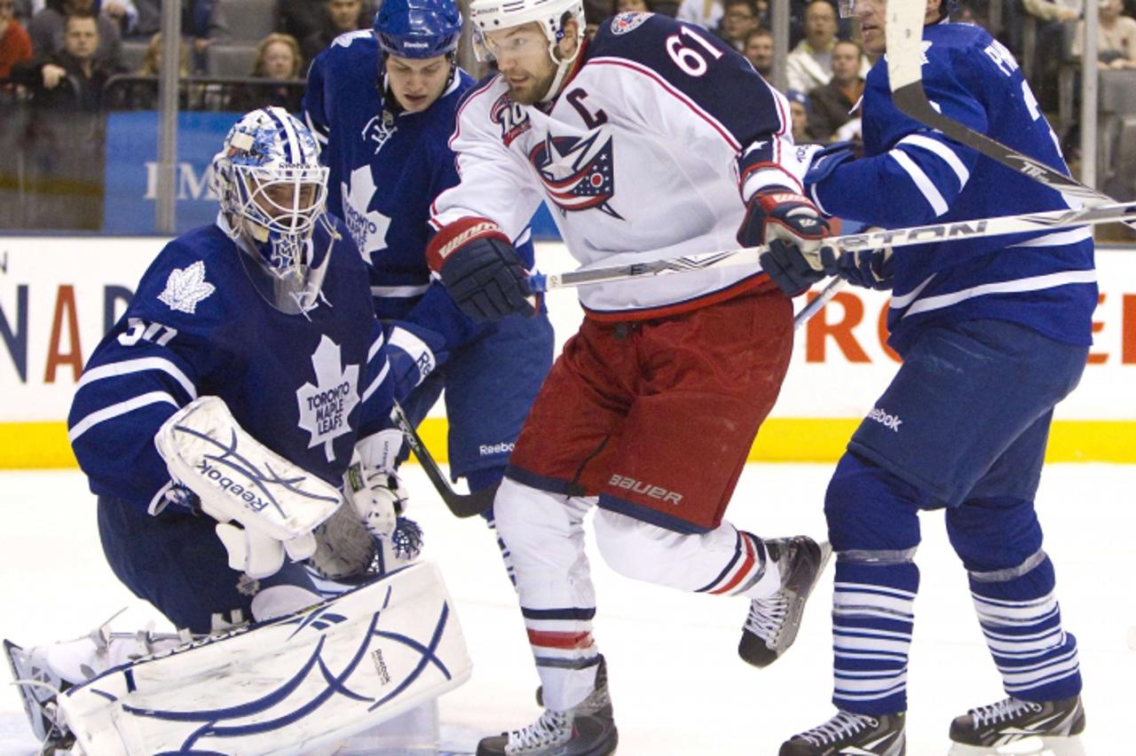 'Columbus Blue Jackets captain Rick Nash (C) drives the net as Toronto Maple Leafs goalie Jonas Gustavsson looks for the puck in the first period of their NHL hockey game in Toronto in this December 3