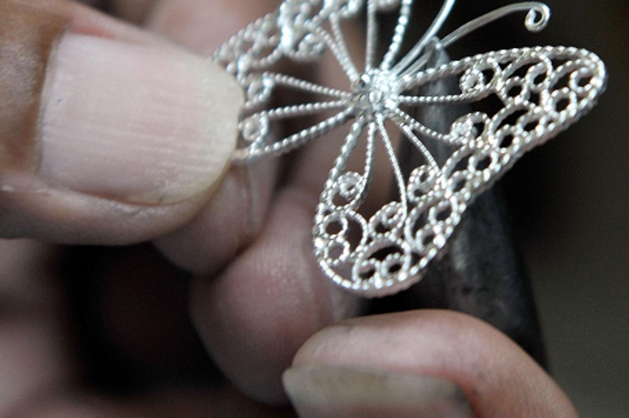 \'A silversmith works on a piece of jewellery at Ibay\'s Silver in the northern Philippine mountain resort city of Baguio, the summer capital of the Philippines, on September 20, 2010. These 92.5 ster