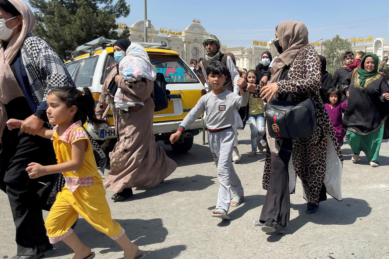 Women with their children try to get inside Hamid Karzai International Airport in Kabul