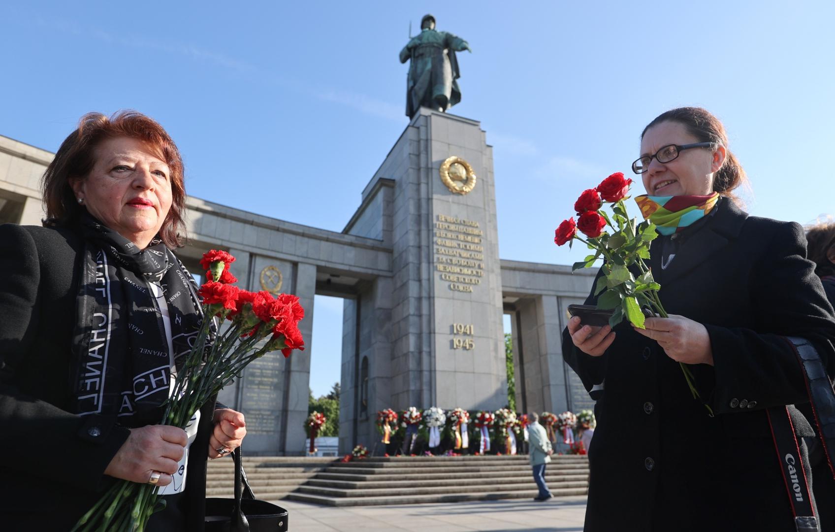 Events commemorating the end of World War Two in Berlin Two women hold carnations to mark Victory Day and the 75th anniversary of the end of World War Two at the Soviet War Memorial at Tiergarten Park in Berlin, Germany, May 8, 2020. REUTERS/Fabrizio Bensch FABRIZIO BENSCH