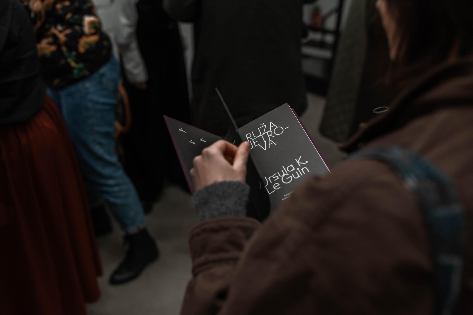 Zbirka priča "Ruža vjetrova", izvorno objavljena 1982. godine, jedna je od ključnih knjiga Ursule K. Le Guin. Dvadeset priča podijeljenih u šest poglavlja nazvanih po smjerovima vjetra ne funkcionira kao klasična žanrovska cjelina, već kao suptilno isprepleten sustav unutarnjih i vanjskih krajolika