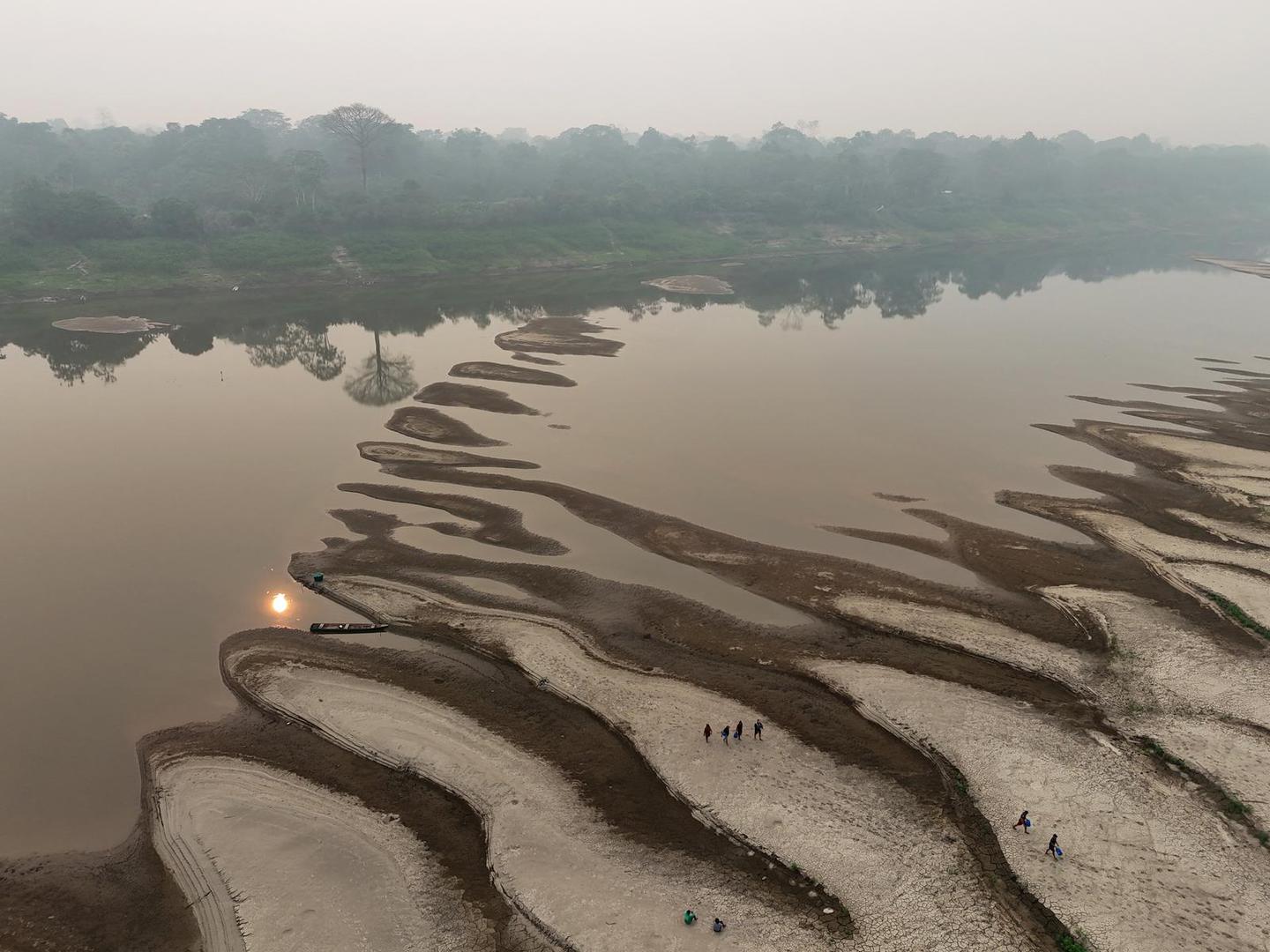 A drone view shows river dwellers carrying water gallons on the sandbanks of the Madeira river to bring to the isolated region of Paraizinho community, during the worst drought of the river in history, Humaita, Amazonas state, Brazil September 8, 2024. REUTERS/Bruno Kelly Photo: BRUNO KELLY/REUTERS