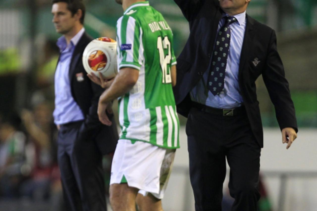 'Real Betis' coach Pepe Mel reacts next to Olympique Lyon's coach Remi Garde during their Europa League Group I soccer match in Seville, September 19, 2013. REUTERS/Marcelo del Pozo (SPAIN - Tags: S