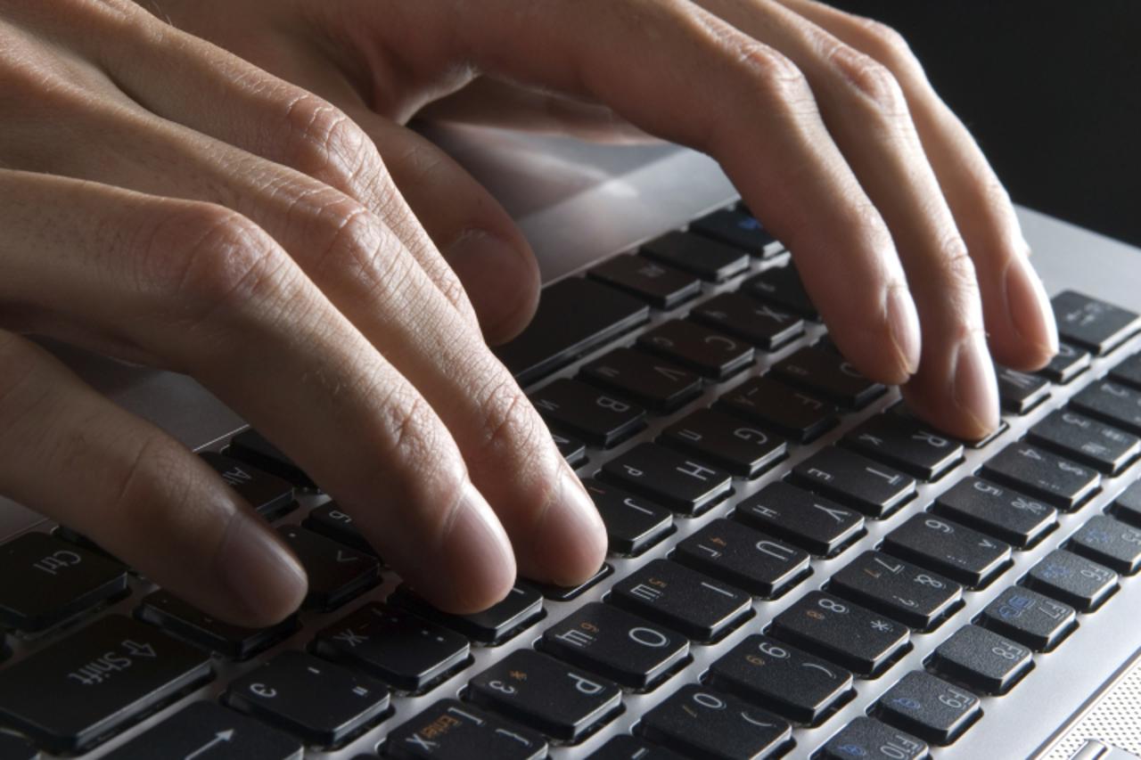 'male hands typing on a laptop'