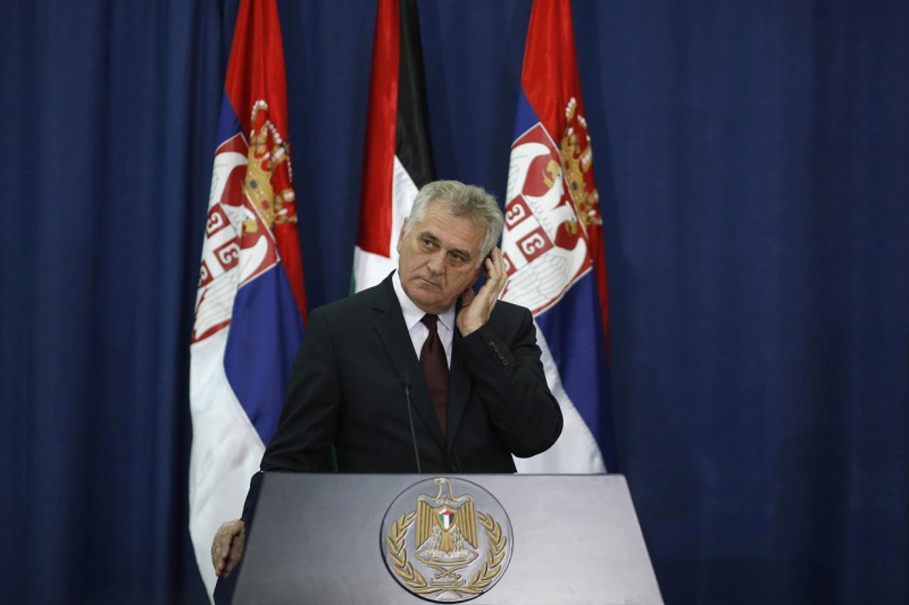 'Serbian President Tomislav Nikolic adjusts his earpiece during a joint news conference with Palestinian President Mahmoud Abbas (not pictured) in the West Bank city of Ramallah May 1, 2013. REUTERS/M