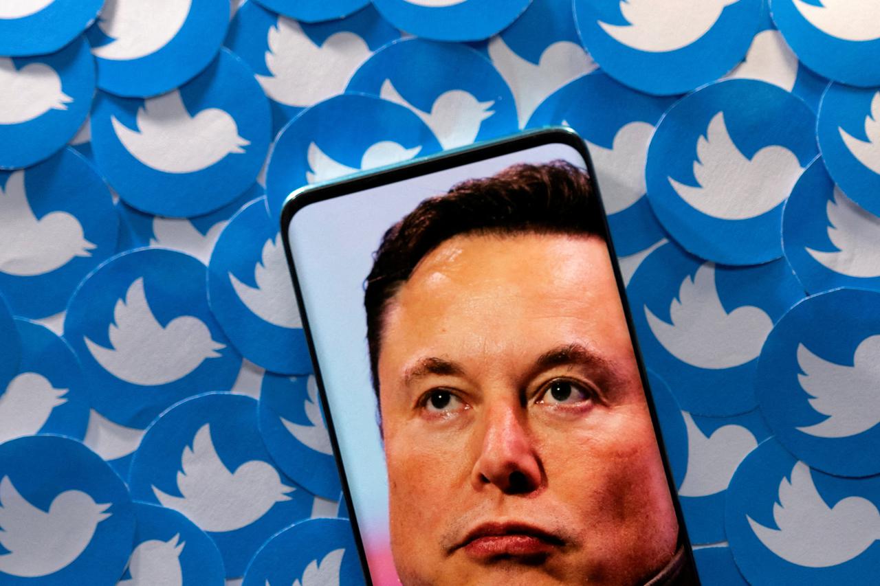 FILE PHOTO: Illustration shows Elon Musk image on smartphone and printed Twitter logos