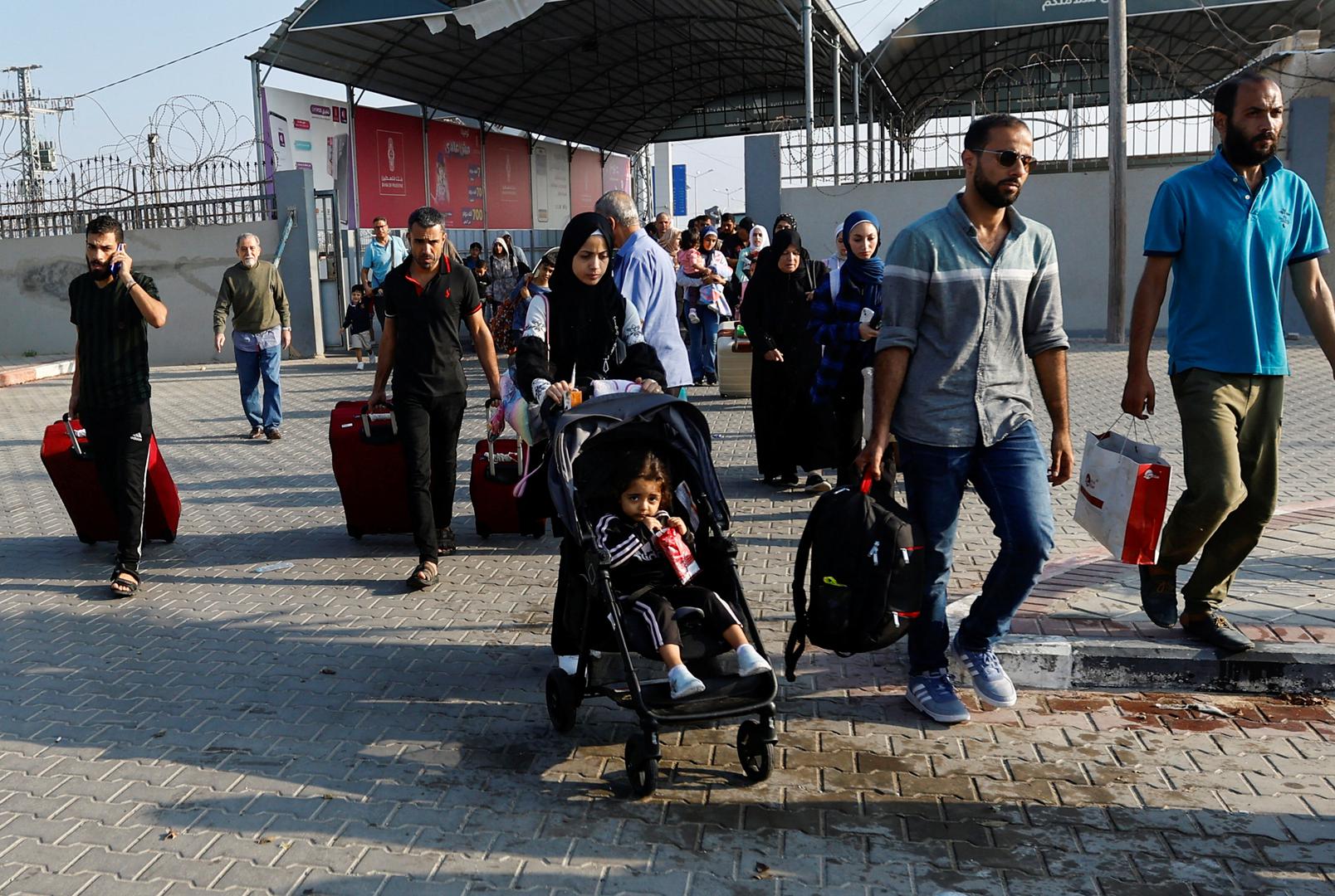 Palestinians with dual citizenship walk as they wait for permission to leave Gaza, amid the ongoing conflict between Israel and Palestinian Islamist group Hamas, at the Rafah border crossing with Egypt, in Rafah in the southern Gaza Strip, November 2, 2023. REUTERS/Ibraheem Abu Mustafa Photo: IBRAHEEM ABU MUSTAFA/REUTERS