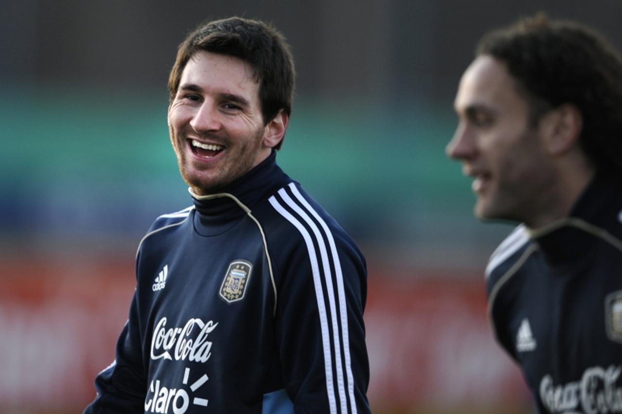 'Argentina\'s forward Lionel Messi (L) laughs next to defender Gabriel Milito during a training session of the national football team in Ezeiza, Buenos Aires on June 27, 2011, ahead of the Copa Americ