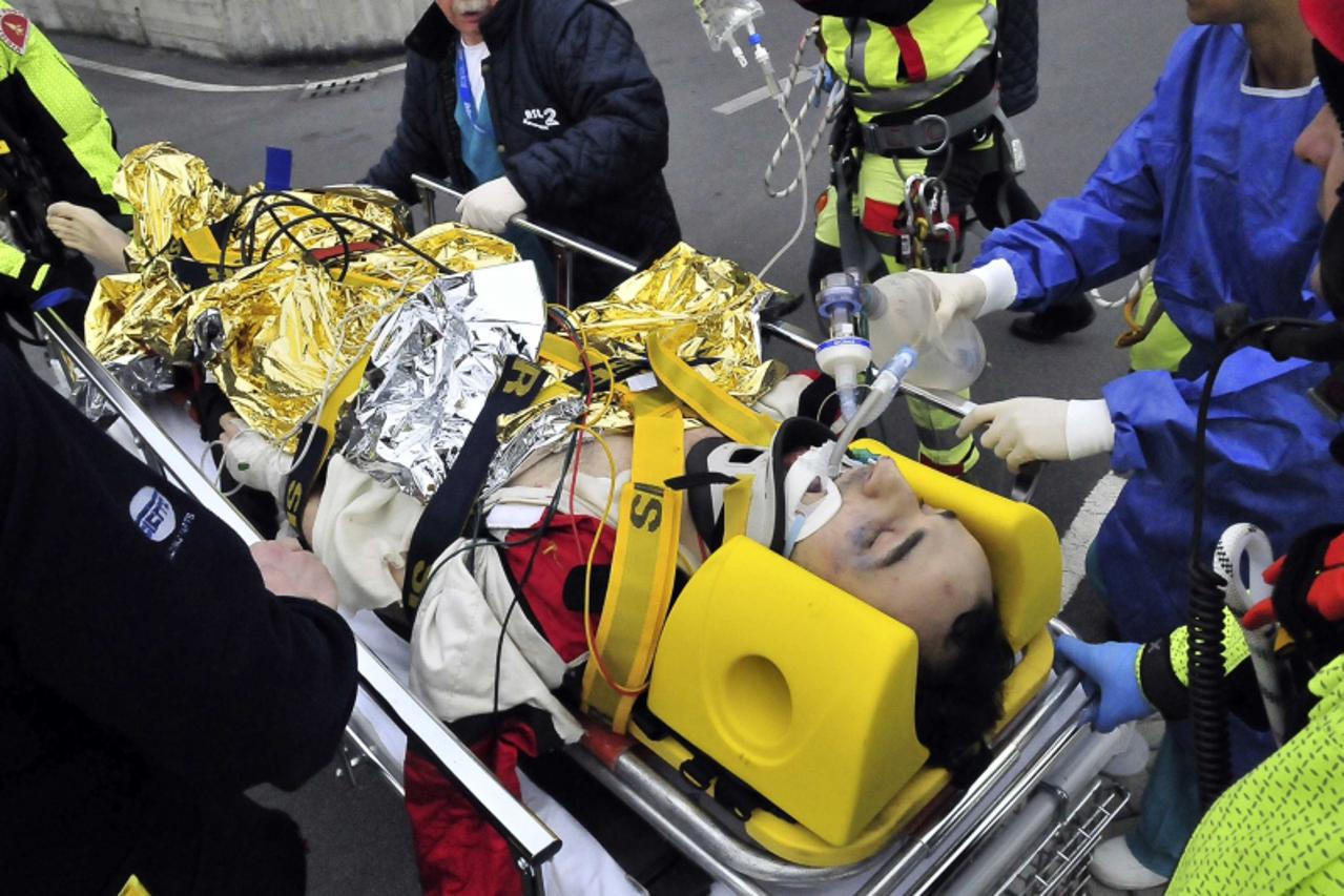 'Rescue workers carry Formula One driver Robert Kubica of Poland following an accident in a rally car during a minor rally near Genoa February 6, 2011. Kubica risks losing the use of his hand after su