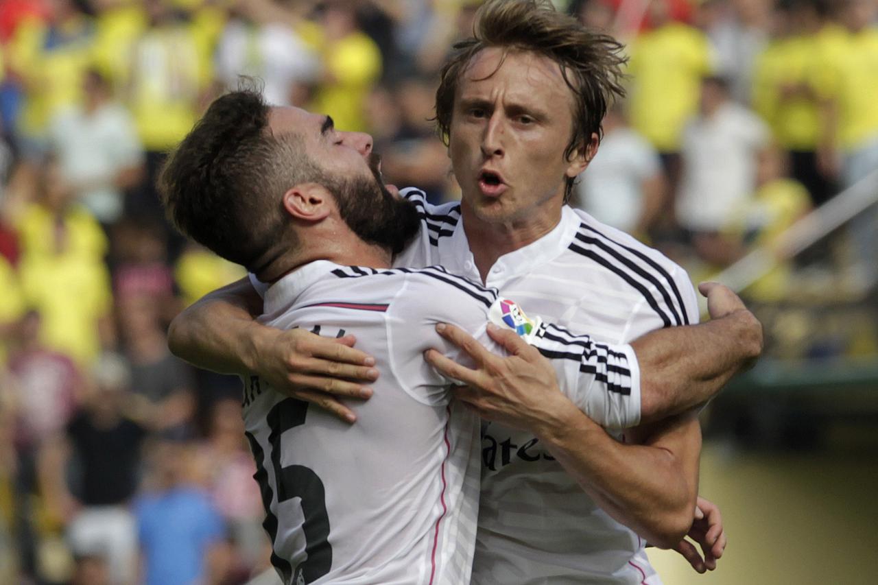 Real Madrid's Luka Modric (R) celebrates with team mate Daniel Carvajal after he scored against Villarreal during their Spanish first division soccer match at the Madrigal stadium in Villarreal September 27, 2014. REUTERS/Heino Kalis (SPAIN - Tags: SPORT 