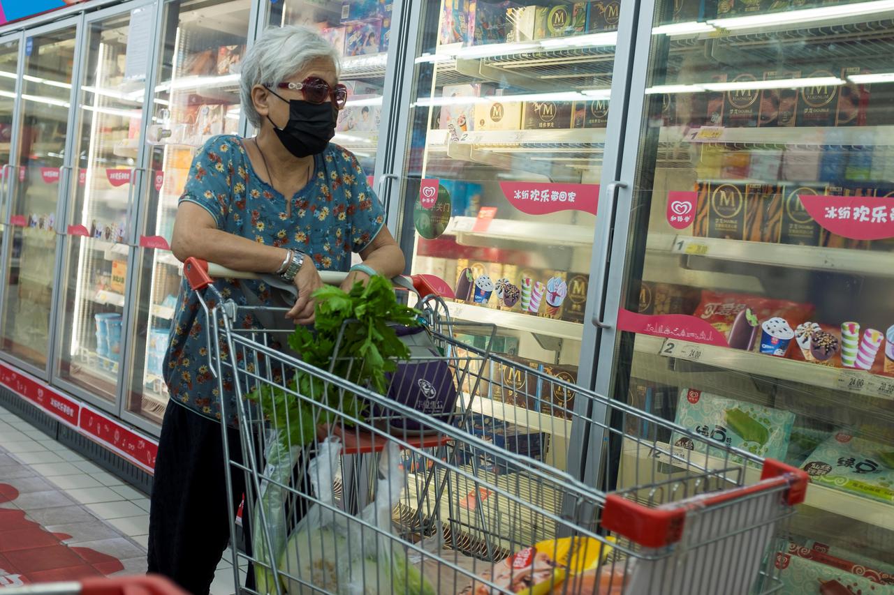 A woman looks at frozen food products in a supermarket in Beijing