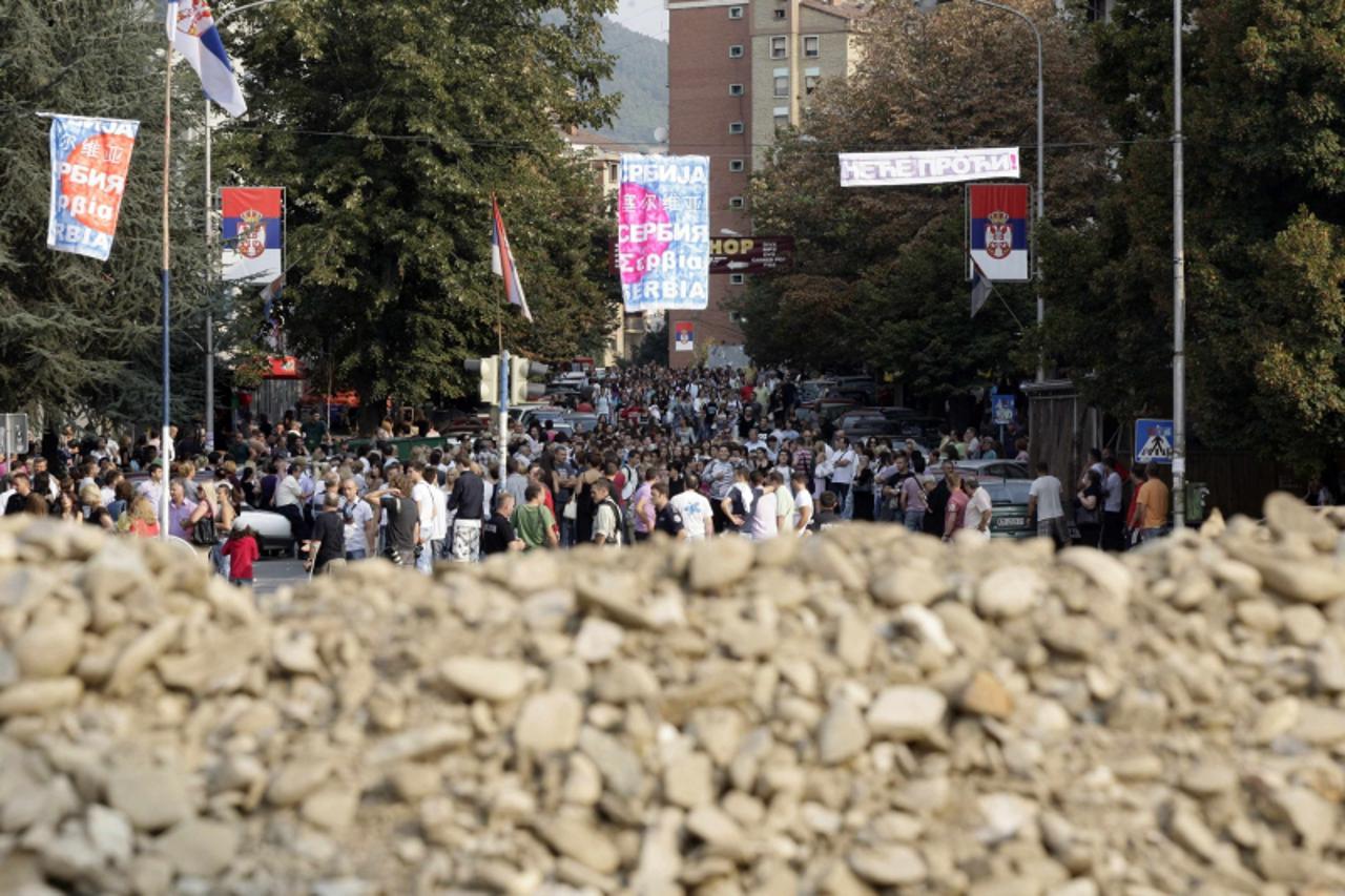 'People stand behind barricades set up on the main bridge in the ethnically divided town of Mitrovica September 16, 2011. Kosovan and European Union police and customs officers were deployed at two co