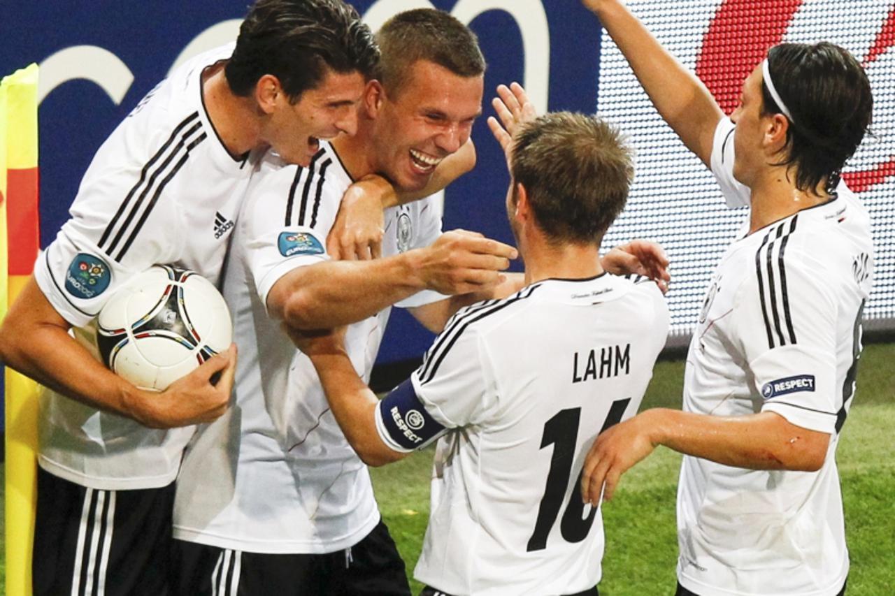 'Germany\'s Lukas Podolski (2L) celebrates with team mates Mario Gomez (L), Philipp Lahm and Mesut Oezil (R) after scoring a goal against Denmark during their Euro 2012 Group B soccer match at the new
