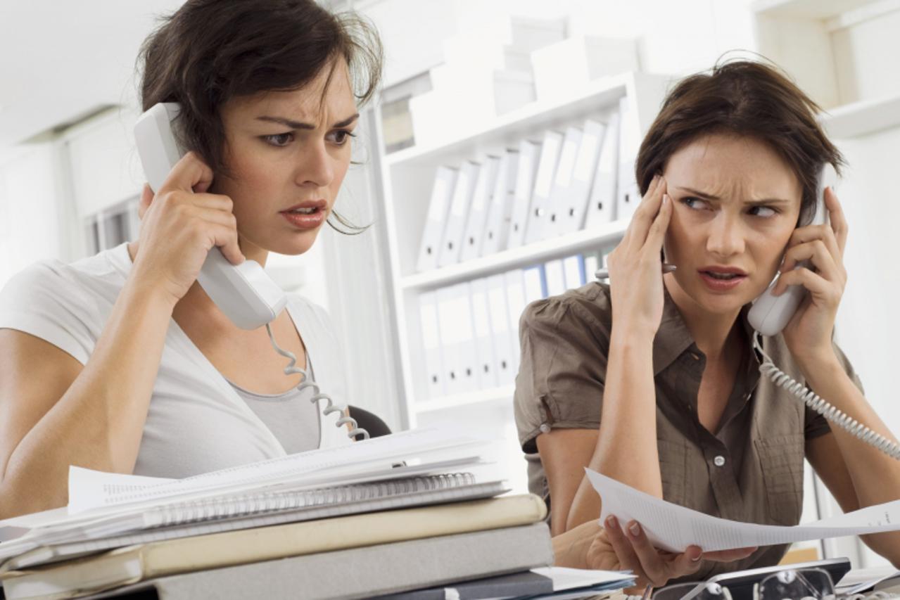 'Businesswomen talking on phones in office'
