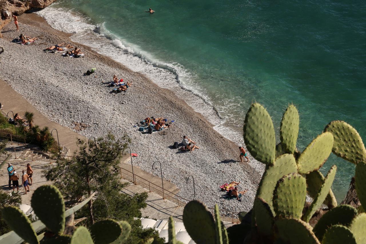 People enjoy  sunny weather by the sea in Greece
