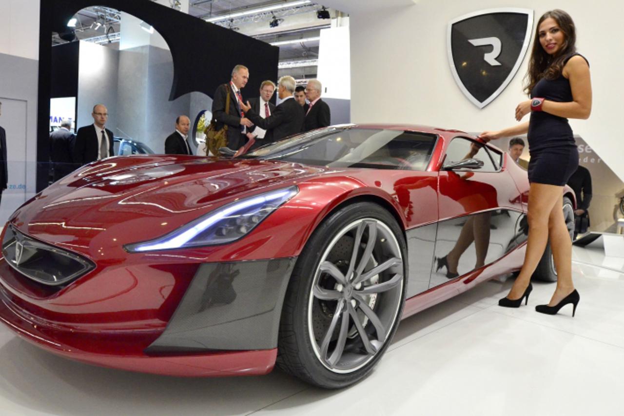 'A model poses next to an electric sportscar of Croatian car producer Rimac Automobili at the international motor show IAA (Internationale Automobil-Ausstellung) in Frankfurt/M, western Germany, on Se