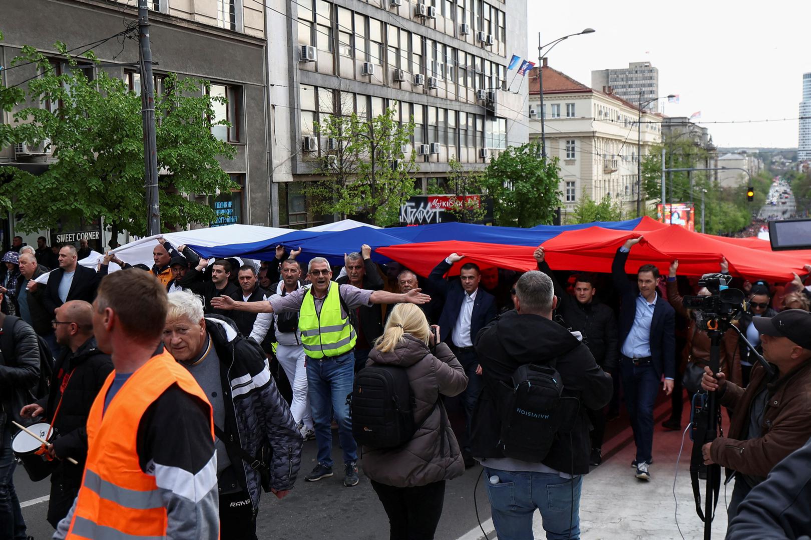 People hold a giant Serbian flag during a rally in support of policies of the President Aleksandar Vucic and to express opposition to months of student protests across the country, in Belgrade, Serbia, April 11, 2025. REUTERS/Zorana Jevtic Photo: ZORANA JEVTIC/REUTERS