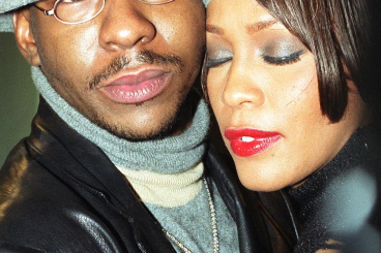 'American R\'n\'B singer Bobby Brown hugs his wife, soul singer Whitney Houston, at a gala reception held at the Waldorf Hotel in London, to celebrate  8 million sales of her current album.    26/08/0
