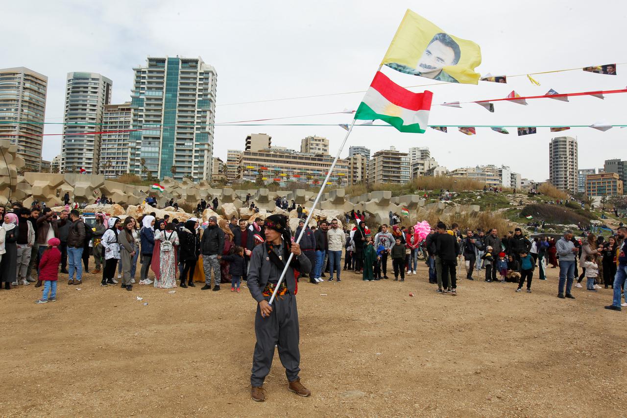A Kurdish man carries a flag with a portrait of jailed Kurdistan Workers Party (PKK) leader Abdullah Ocalan during Nowruz festival celebrations, in Beirut