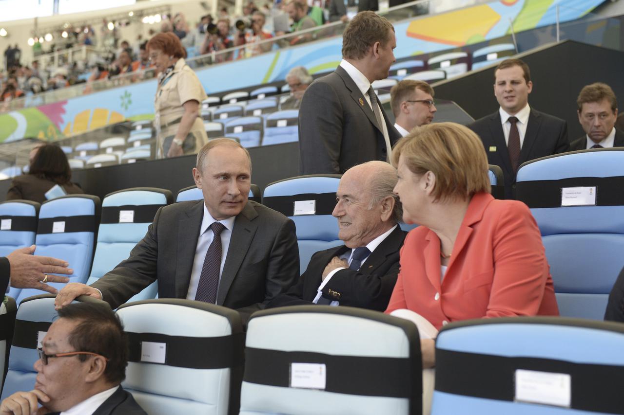 Russian President Vladimir Putin (L) speaks to German Chancellor Angela Merkel and FIFA President Sepp Blatter (C) during the 2014 World Cup final between Germany and Argentina at the Maracana stadium in Rio de Janeiro July 13, 2014. REUTERS/Alexey Nikols