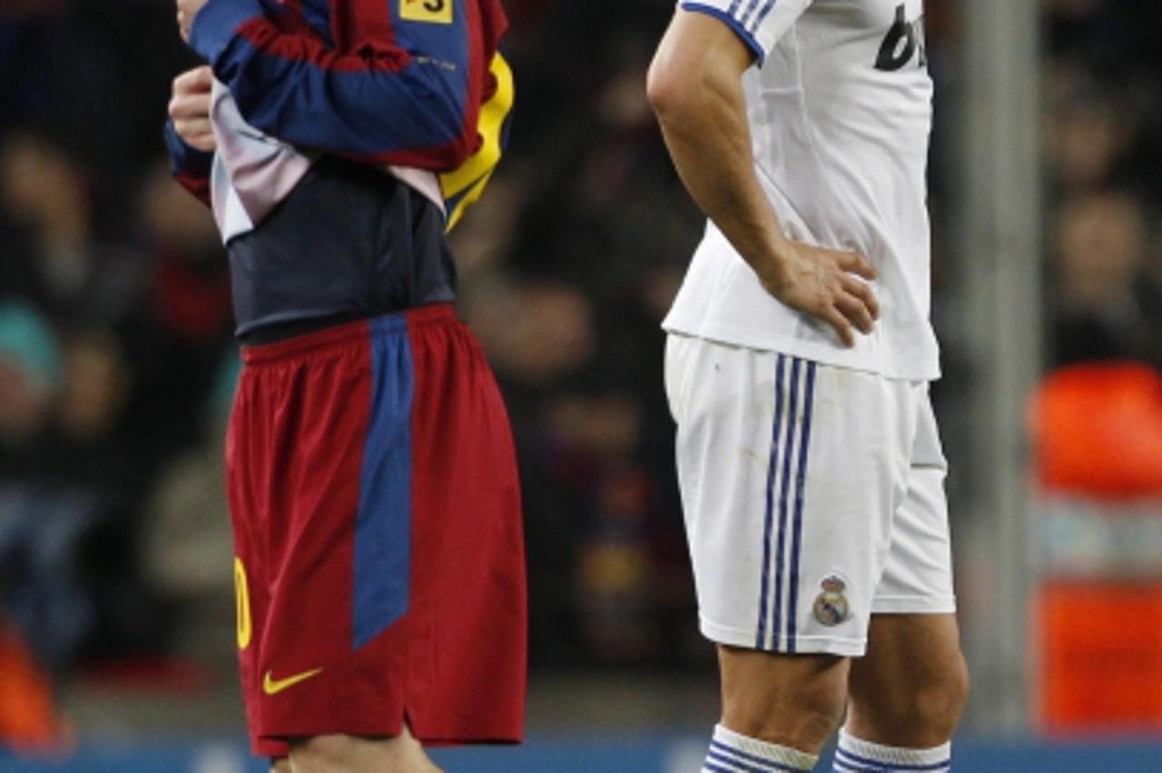 'Real Madrid\'s Cristiano Ronaldo (R) and Barcelona\'s Lionel Messi are seen reacting during their Spanish first division soccer match at Nou Camp stadium in Barcelona in this November 29, 2010 file p