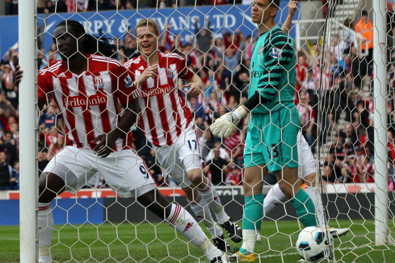 'Stoke City\'s Trinidadian player Kenwyne Jones (L) prepares to celebrate after deflecting the ball into the net past Arsenal\'s Polish goalkeeper Wojciech Szczesny (R) to score the opening goal durin