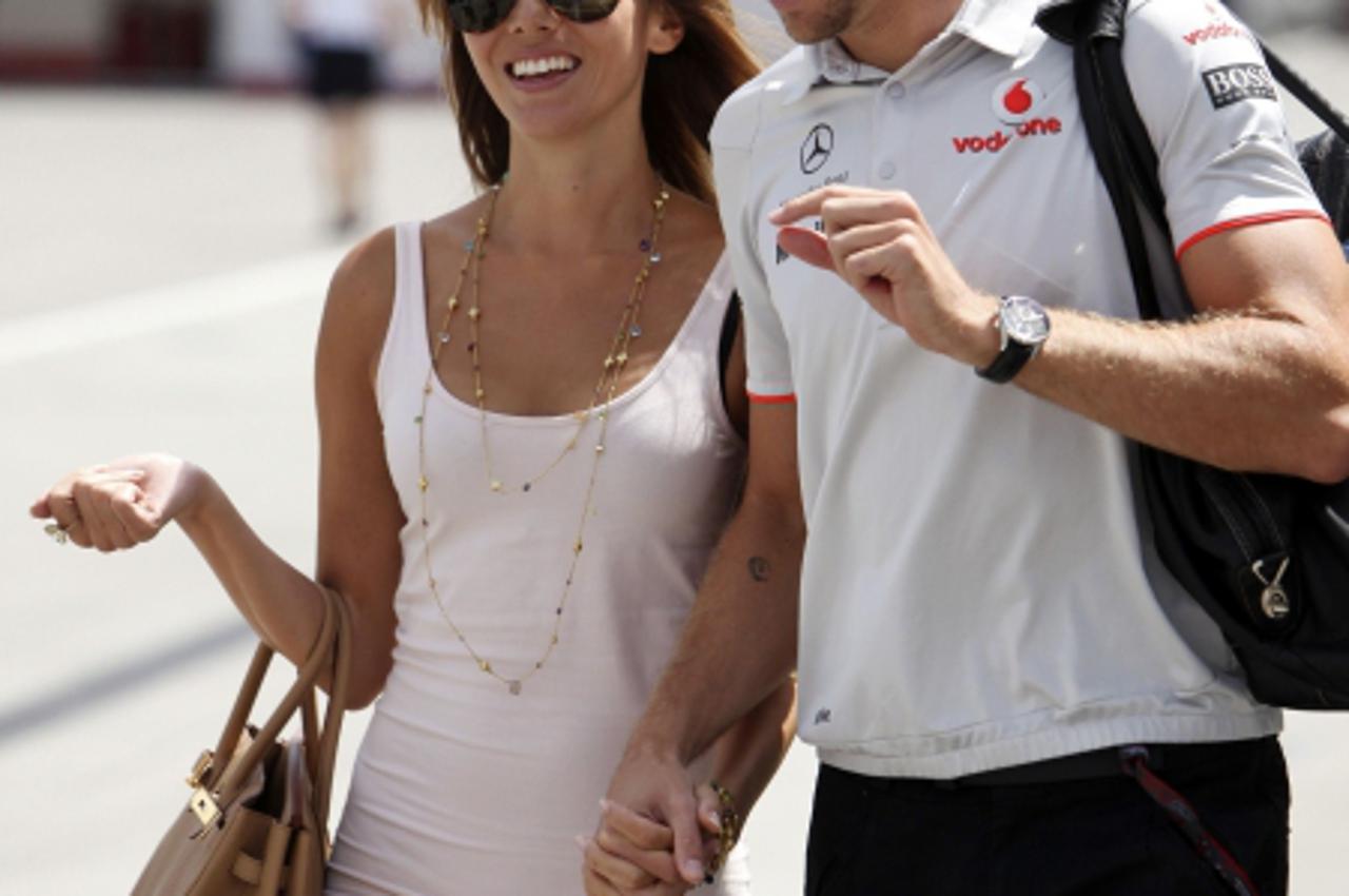 'McLaren Formula One driver Jenson Button of Britain arrives with his girlfriend Jesica Michibata to the Hungaroring circuit near Budapest July 29, 2010, ahead of the Hungarian F1 Grand Prix. REUTERS/