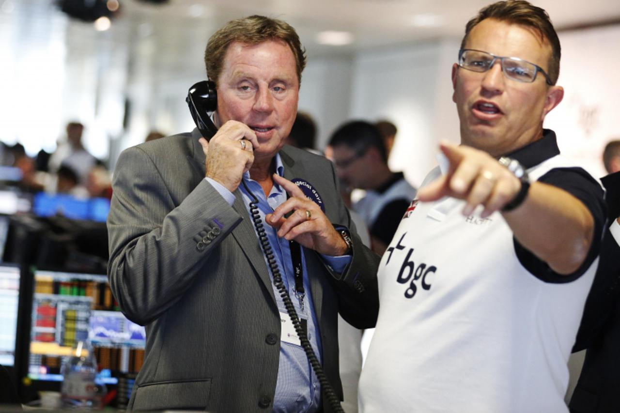 'Football manager Harry Redknapp talks on the phone on the trading floor of BGC Partners, in London September 11, 2012. The company, formerly part of Cantor Fitzgerald, holds a Charity Day each year t
