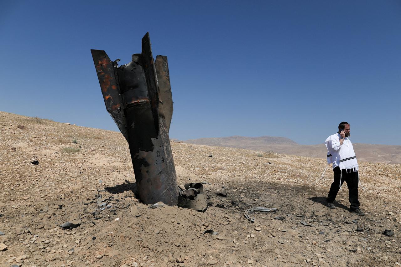 Part of a missile protrudes from the ground, following strikes from Iran, in the central Israeli-occupied West Bank