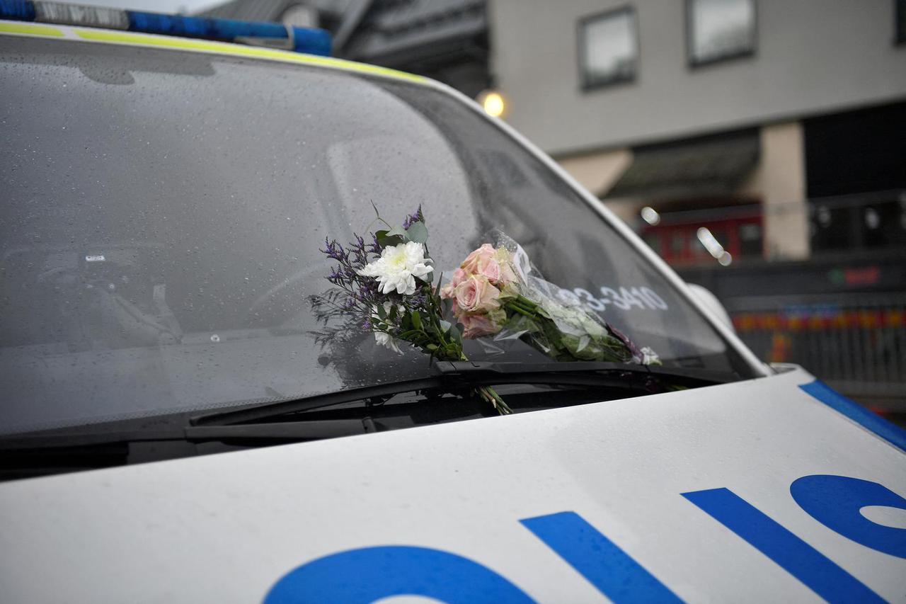 A police car with flowers attached to the windshield is parked in the street, the morning after the school shooting at Risbergska School in Orebro