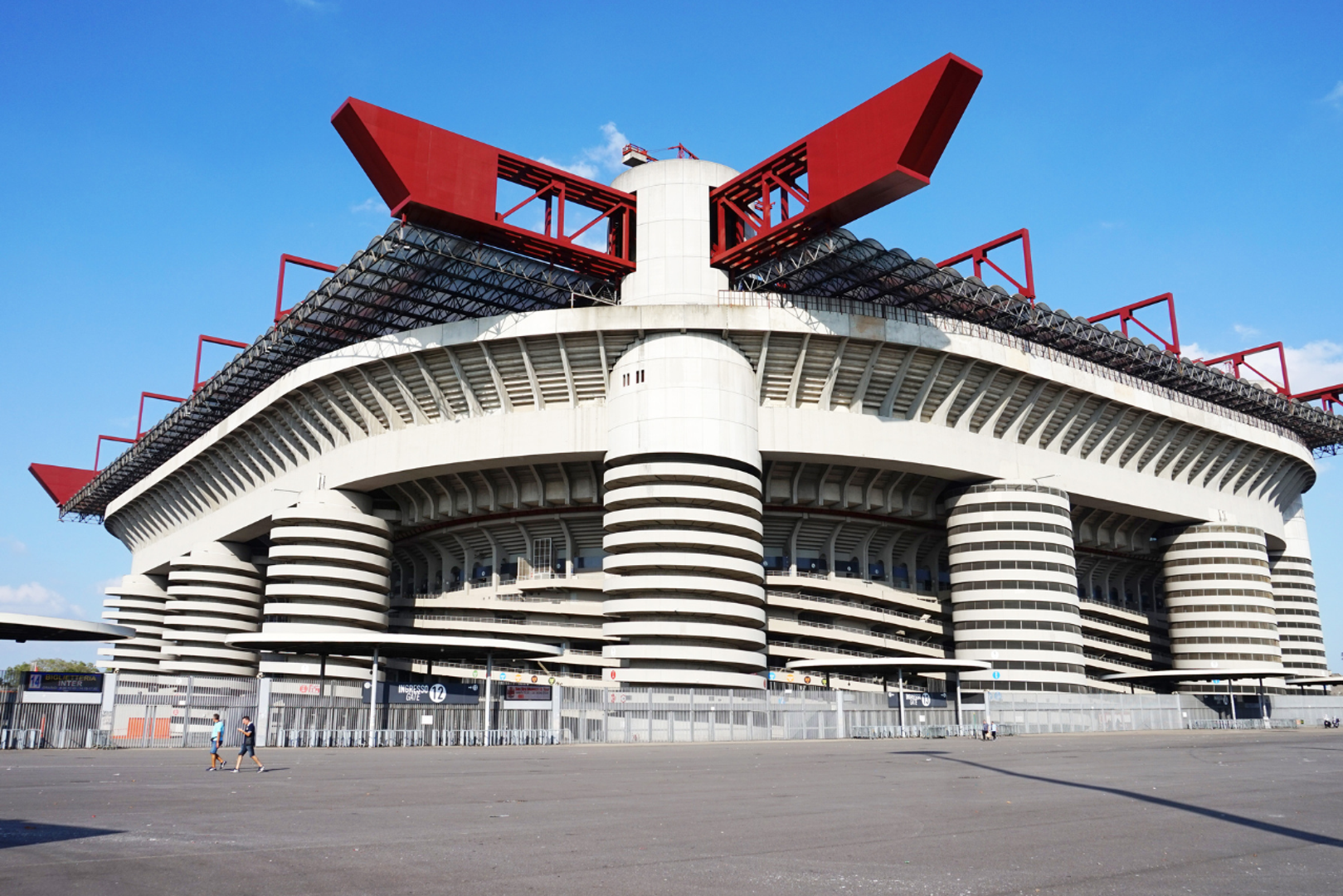 Ako se vratimo izvornoj nogometnoj romantici, proslavljeni milanski San Siro predstavlja suštu suprotnost modernim blještavim arenama. Dom dvaju velikih i trofejnih talijanskih rivala prava je brutalistička ikona čiji masivni spiralni betonski tornjevi i izuzetno prepoznatljivi crveni krovni nosači tvore potpuno jedinstvenu sliku. Iako mu već godinama ozbiljno prijeti rušenje zbog raznih planova za izgradnju potpuno novog objekta, njegova nevjerojatna sirova betonska ljepota osigurava mu trajno, duboko urezano mjesto na prestižnoj listi najimpresivnijih svjetskih arena koje su oblikovale brojne generacije.