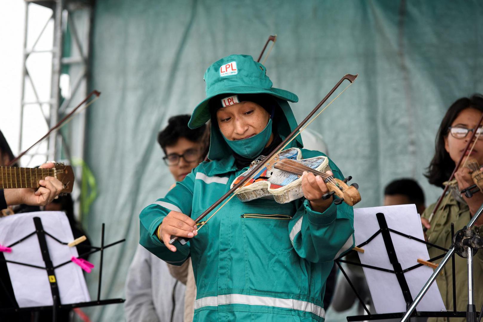 Yessica Llanco, a recycler from the city of La Paz, learns to play the violin made with recycled materials with the Paraguayan Cateura Recycled Instruments Orchestra, at the Sak'a Churu landfill in Alpacoma, in La Paz, Bolivia on February 27, 2023. REUTERS/Claudia Morales Photo: CLAUDIA MORALES/REUTERS