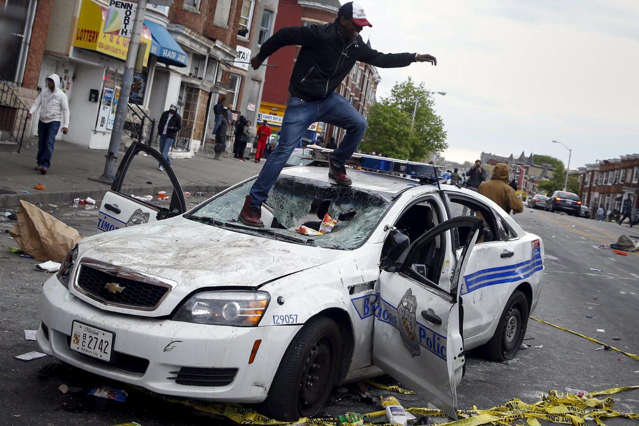 ATTENTION EDITORS - REUTERS PICTURE HIGHLIGHT  Demonstrators jump on a damaged Baltimore police department vehicle during clashes in Baltimore, Maryland April 27, 2015.  REUTERS/Shannon Stapleton      TPX IMAGES OF THE DAY  REUTERS NEWS PICTURES HAS NOW M