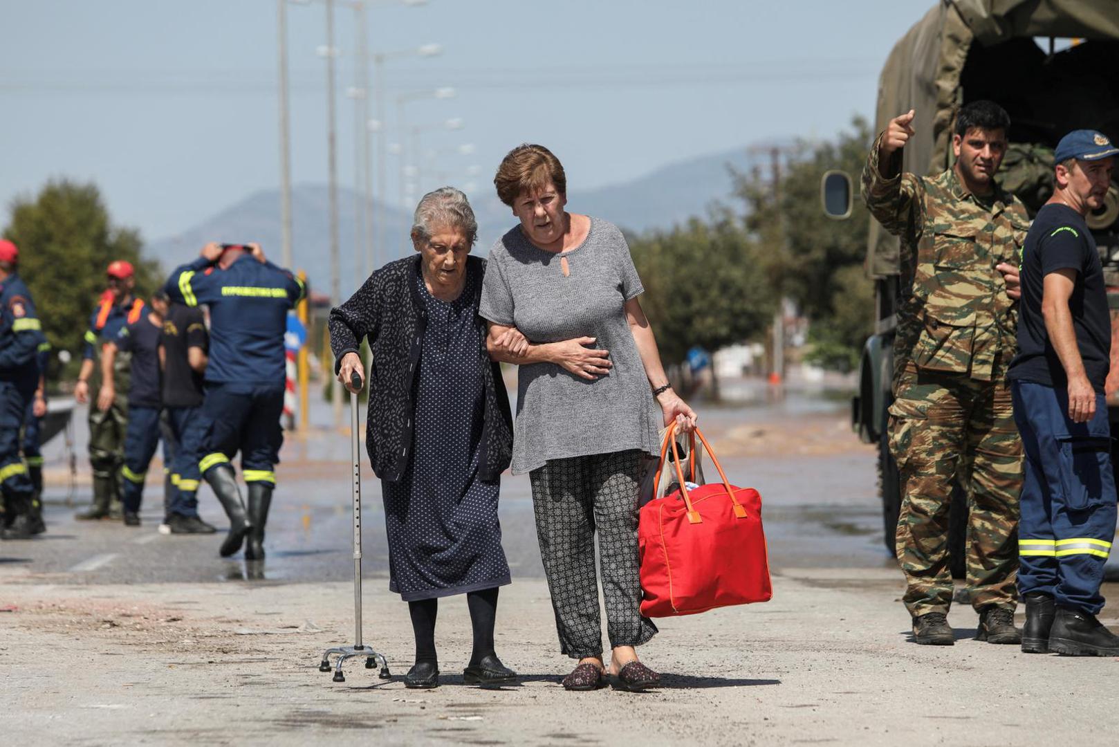 Two women leave a flooded area after being evacuated, in the aftermath of Storm Daniel, in Larissa, Greece, September 10, 2023. REUTERS/Elias Marcou Photo: ELIAS MARCOU/REUTERS