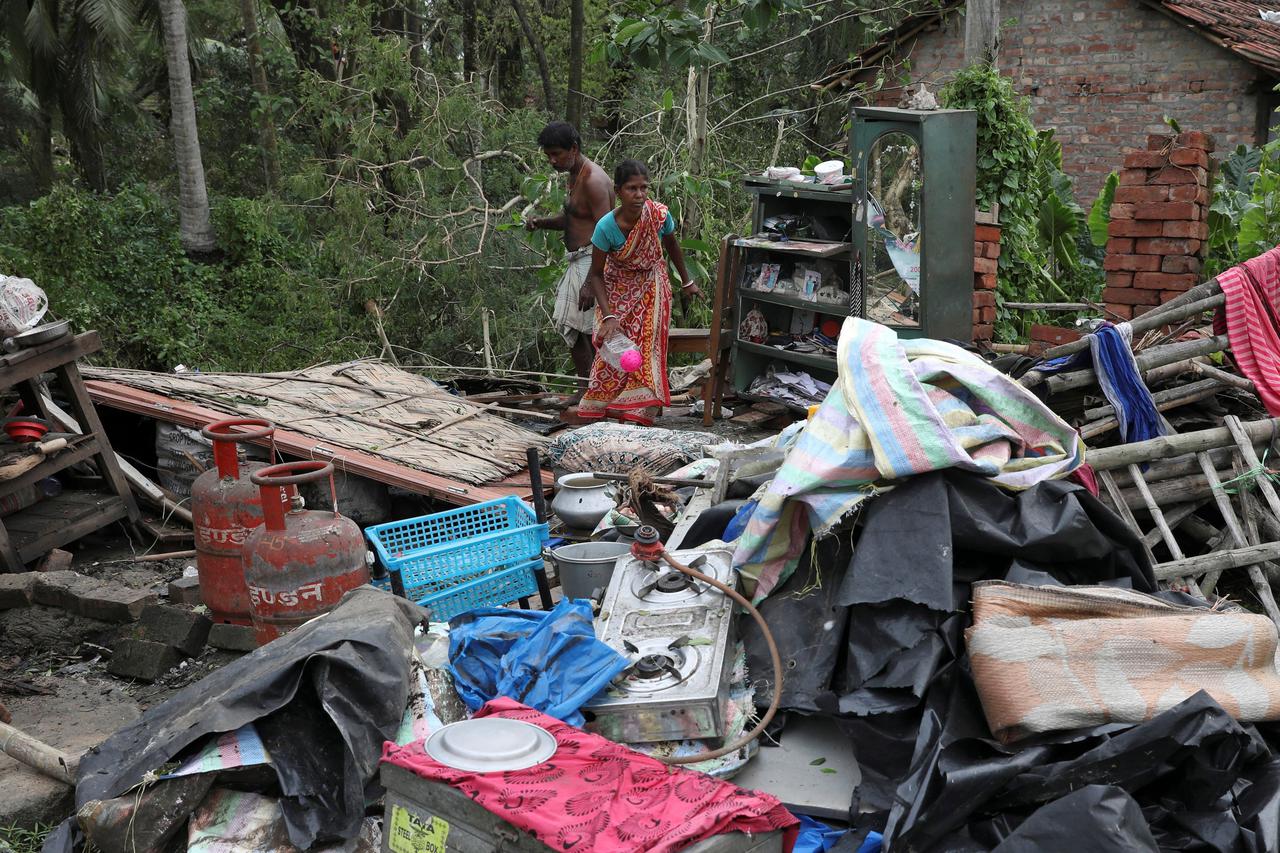 Residents salvage their belongings from the rubble of a damaged house in the aftermath of Cyclone Amphan, in South 24 Parganas