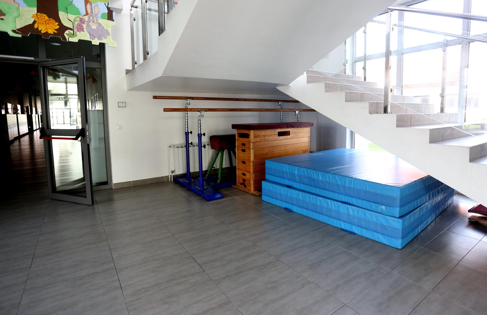 Strunjače, kozlić, sanduk i prečke stoje ispod stepenica koje vode na kat