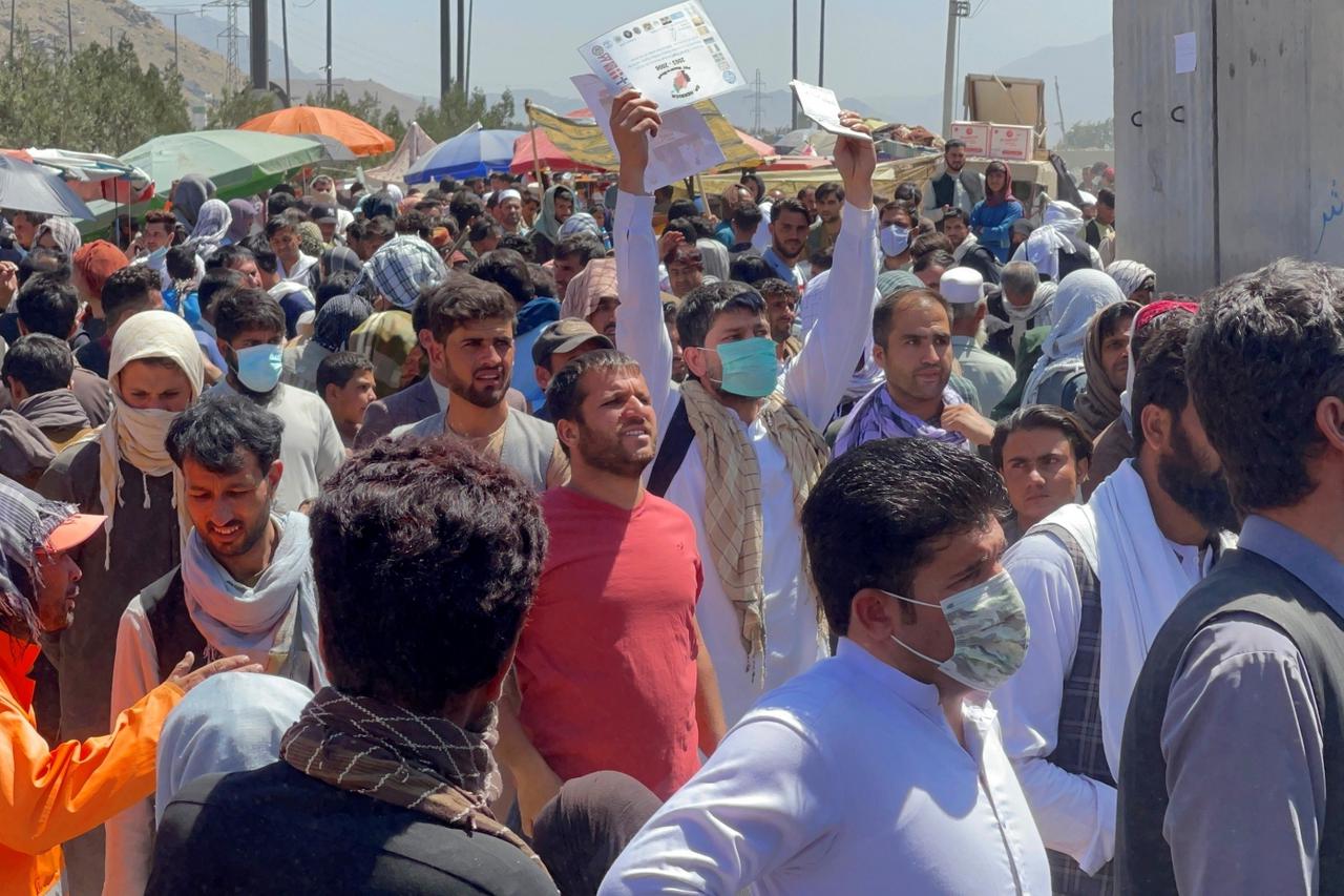 Crowds of people show their documents to U.S. troops outside the airport in Kabul