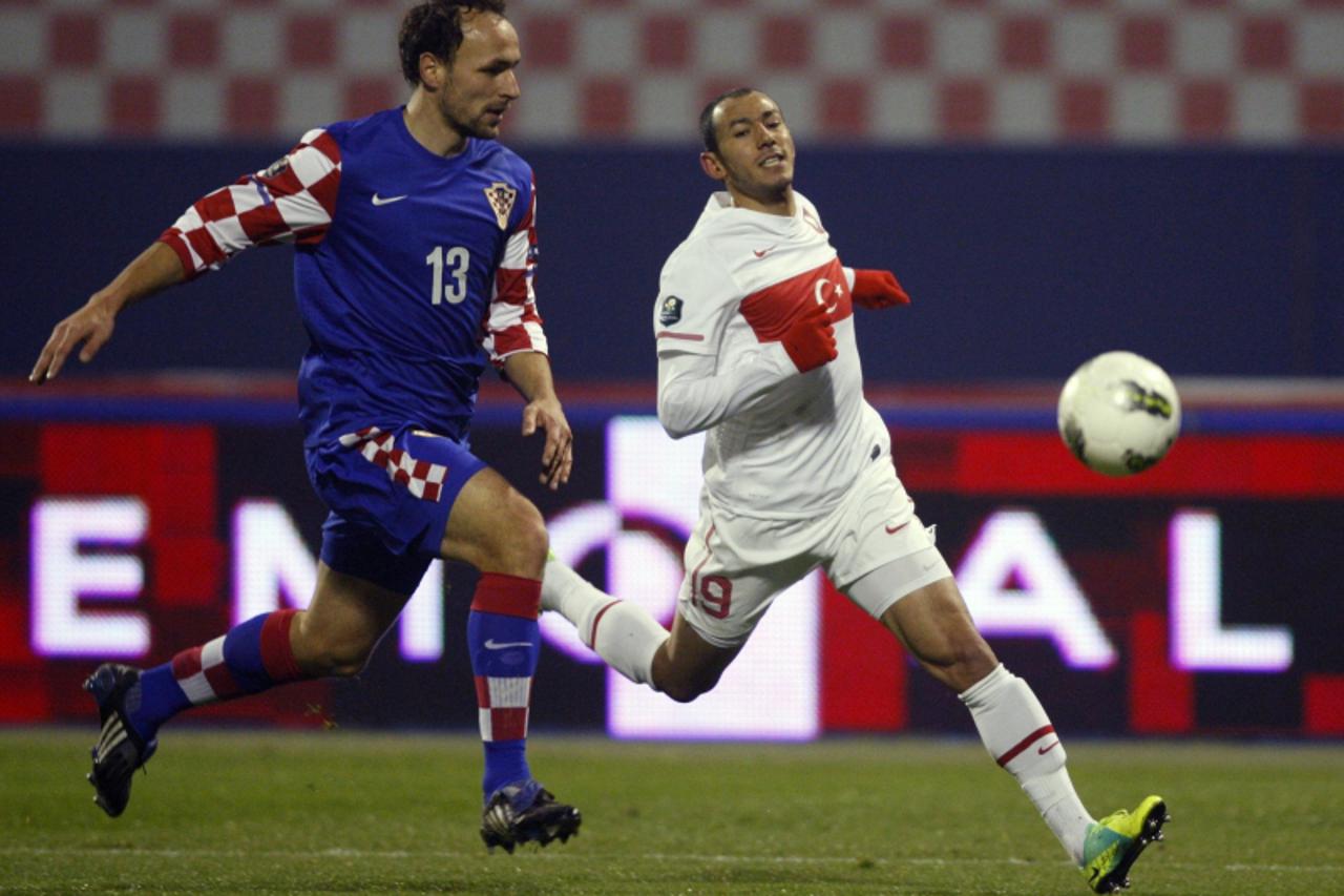 'Hamit Altintop (R) of Turkey challenges Gordon Schildenfeld of Croatia during their Euro 2012 playoff qualifying soccer match at Maksimir stadium in Zagreb November 15, 2011.    REUTERS/Nikola Solic 