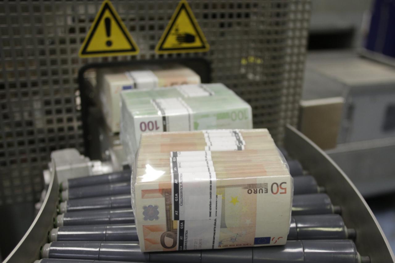 'Bundles of euro banknotes move along a conveyer belt at the GSA Austria (Money Service Austria) company\'s headquarters in Vienna July 22, 2013. The GSA delivers new and collects old currency for the