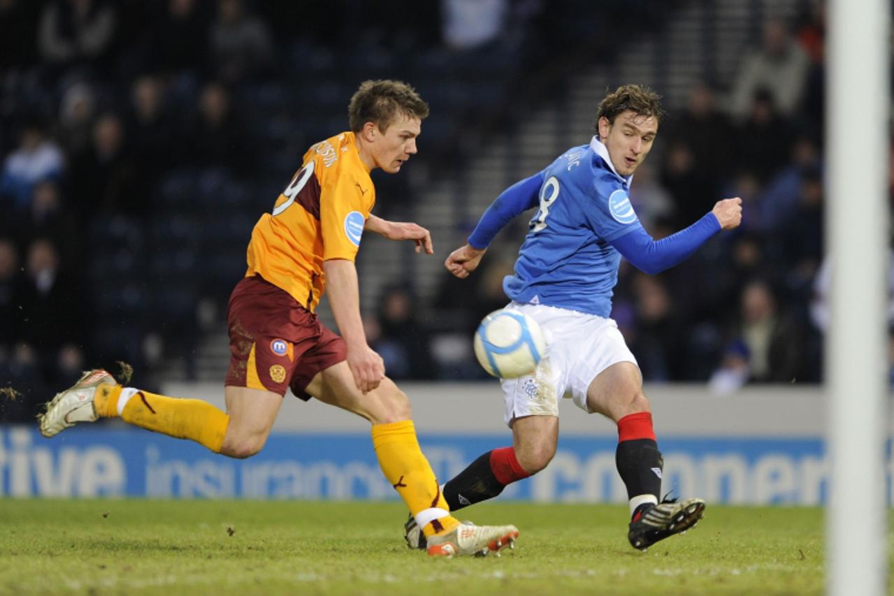 \'Motherwell\'s Shaun Hutchinson challenges Rangers\' Nikica Jelavic as he sets up goal for Steven Naismith during their Scottish League Cup semi final soccer match at Hampden Park in Glasgow, Scotlan