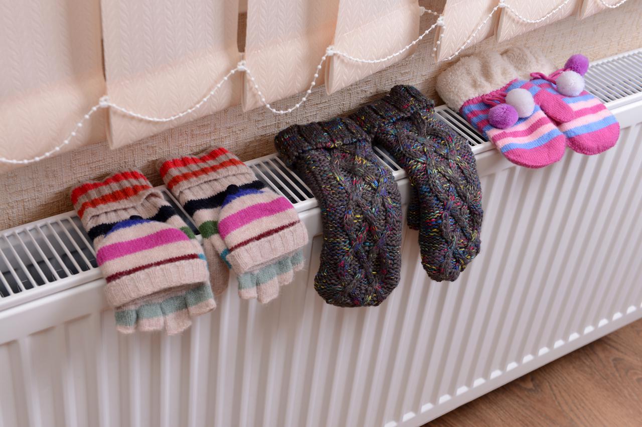 Knitted gloves drying on heating radiator