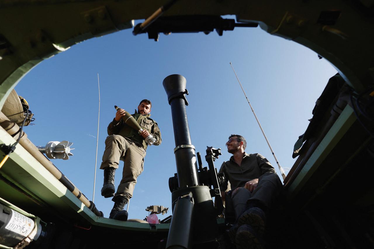 Israeli soldiers fire a mortar as the conflict continues between Israel and Hamas