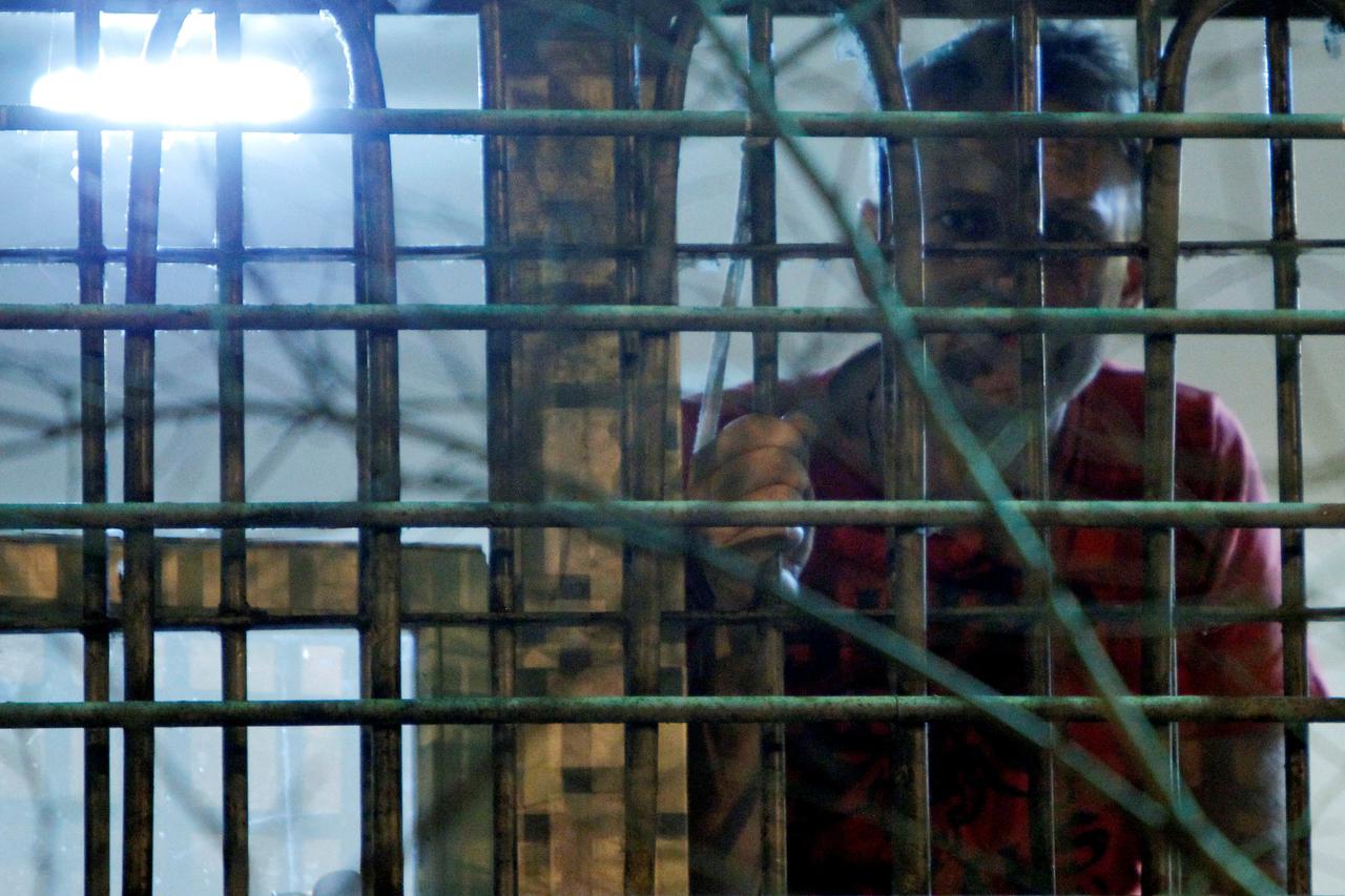 FILE PHOTO: Russian anti-corruption blogger Navalny looks out of the window of his cell in a detention centre in Moscow