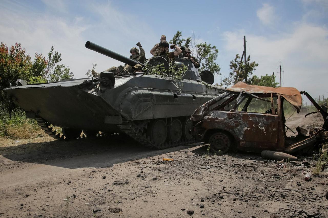 Ukrainian service members ride a BMP-1 infantry fighting vehicle near the front line in the newly liberated village Neskuchne