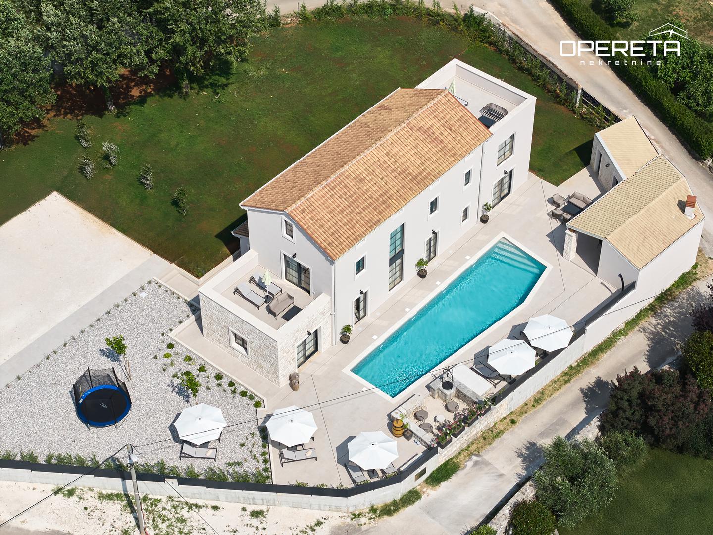 Impresivna nekretnina ukupne površine 320 m² prostire se na prostranoj parceli od 2000 m², nudeći privatnost i obilje prostora.


