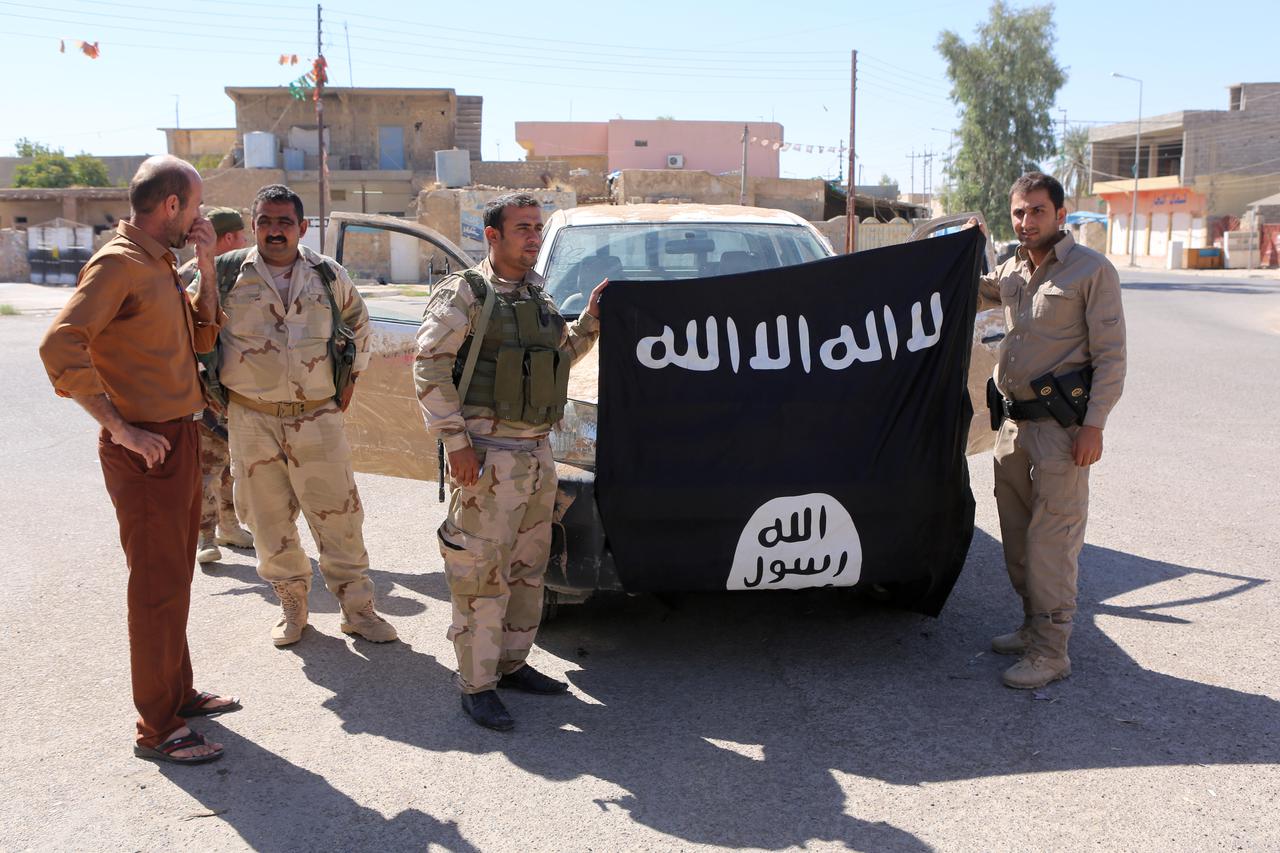 Kurdski borci poziraju s otetom zastavom Islamske države
