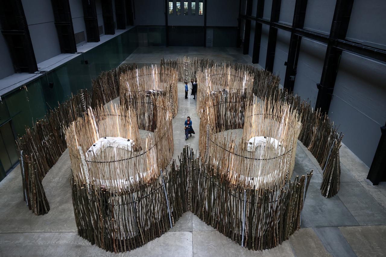 Visitors walk around a sculpture titiled 'Goavve-Geabbil' by Sami-Norwegian artist Maret Anne Sara at the Tate Modern in London