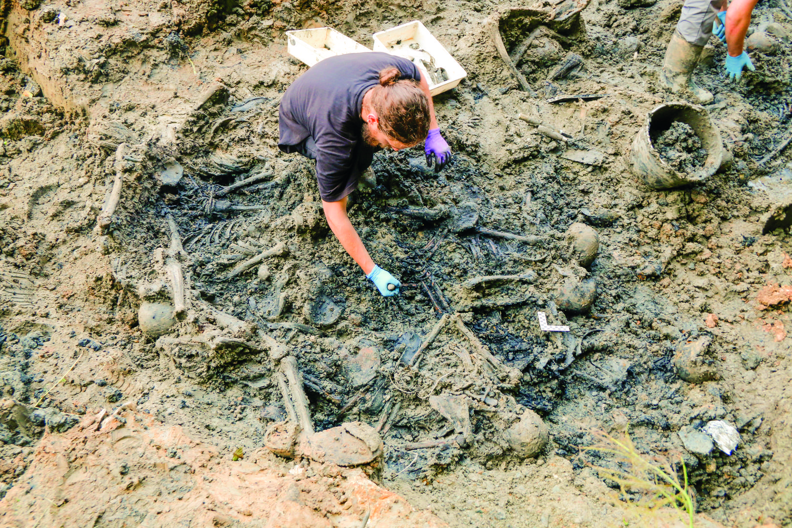 Košnica pri Celju – Grobišče 3. Uroš Košir tijekom iskopavanja posmrtnih ostataka u grobnoj jami br. 1, 2016.
