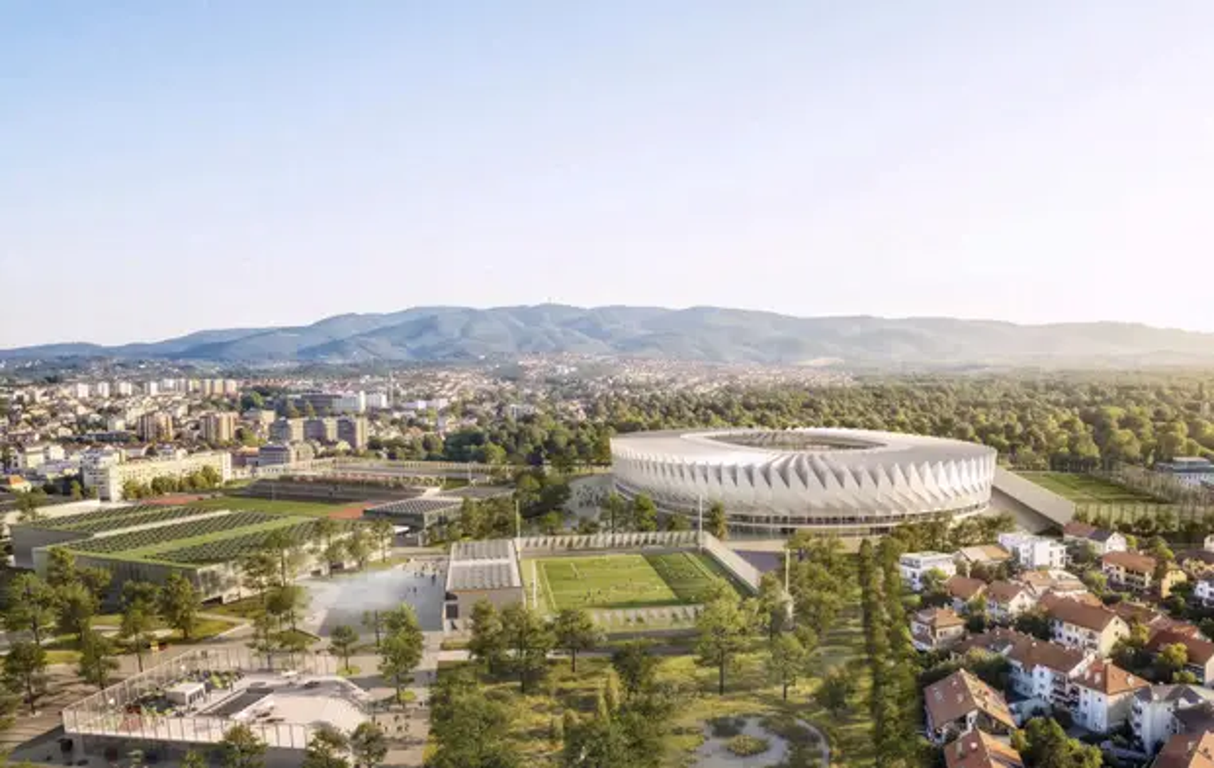 Kružni volumen stadiona obavijen je nizom vitkih, kosih konstruktivnih okvira koji pročelju daju ritam razvijenih zastava, dok se naborani krov uzdiže kao nazubljena kruna izvedena iz siluete Medvednice. Pravokutna tribinska zdjela smještena je unutar slobodnije vanjske geometrije, a oko nje se razvija povišeni javni Korzo s muzejom, trgovinom, ugostiteljstvom i pogledima prema igralištu.