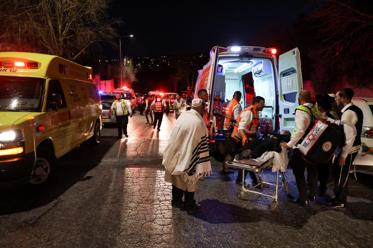 Rescue workers carry injured people outside a synagogue in Givat Zeev